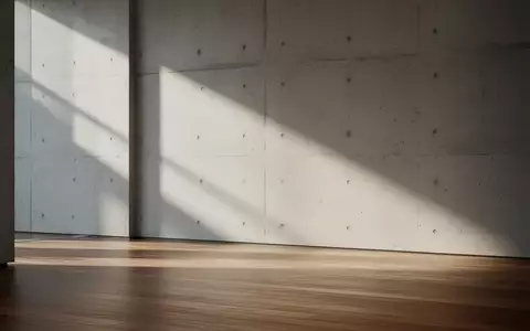 Ein moderner, minimalistischer Innenraum mit klaren Linien und weichem Lichteinfall auf einer Betonwand. - Foto: über boerse-global.de