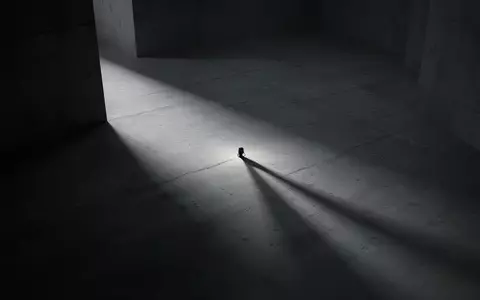 Ein minimalistischer, schattiger Raum mit einer einzelnen Lichtquelle, der Einsamkeit und Konzentration symbolisiert. - Foto: über boerse-global.de