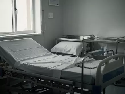 Ein leeres Krankenhausbett in einem sterilen Untersuchungsraum mit natürlichem Lichteinfall. - Foto: über boerse-global.de