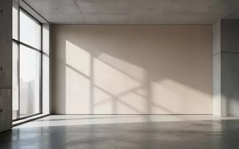 Ein minimalistischer Innenraum mit klaren architektonischen Linien und weichem, natürlichem Licht, das geometrische Schatten wirft. - Foto: über boerse-global.de