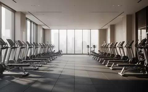 Ein heller, leerer Fitnessraum mit modernen Trainingsgeräten und großen Fensterfronten in einer minimalistischen Umgebung. - Foto: über boerse-global.de