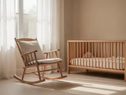 Ein minimalistisch eingerichtetes, helles Kinderzimmer mit einem Schaukelstuhl und sanftem Tageslicht. - Foto: ĂĽber boerse-global.de