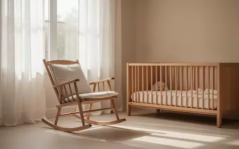 Ein minimalistisch eingerichtetes, helles Kinderzimmer mit einem Schaukelstuhl und sanftem Tageslicht. - Foto: über boerse-global.de