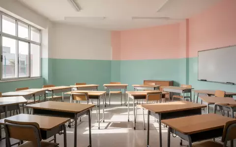Ein leerer, heller Klassenraum in einer mexikanischen Schule mit in einem Halbkreis angeordneten Holztischen und natürlichem Tageslicht. - Foto: über boerse-global.de