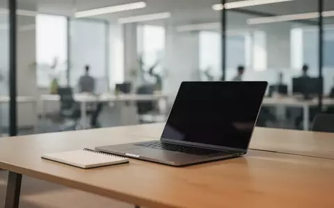 Ein minimalistischer Büroarbeitsplatz mit Laptop und Notizbuch in einer hellen, professionellen Umgebung. - Foto: über boerse-global.de