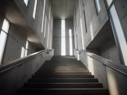 Eine lange, leere Industrietreppe in einem hohen Turm, die von natürlichem Licht durchflutet wird. - Foto: über boerse-global.de