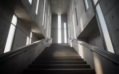 Eine lange, leere Industrietreppe in einem hohen Turm, die von natürlichem Licht durchflutet wird. - Foto: über boerse-global.de