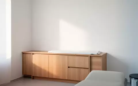 Ein minimalistischer, heller Behandlungsraum in einer Arztpraxis mit Fokus auf eine schlichte Wand und Tageslicht. - Foto: über boerse-global.de