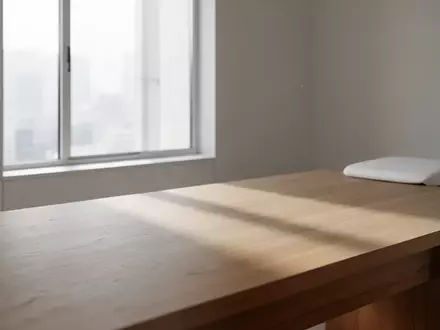 Ein minimalistischer, ruhiger Raum mit natürlichem Licht, das sanfte Schatten auf eine schlichte Holztischoberfläche wirft. - Foto: über boerse-global.de