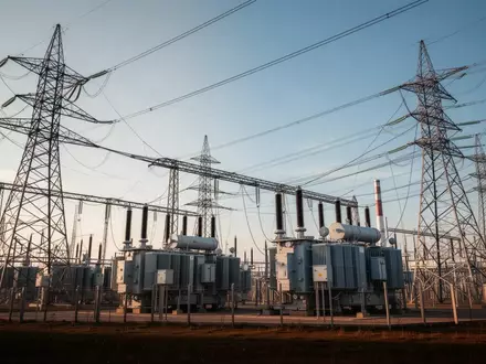 Moderne Industrieanlage mit Strommasten und Transformatoren unter klarem Himmel. - Foto: über boerse-global.de