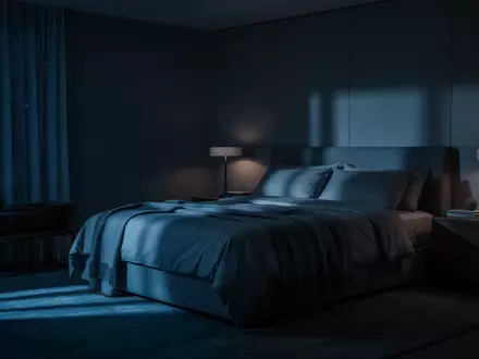Ein schlichtes, in sanftes blaues Licht getauchtes Schlafzimmer bei Nacht, das Ruhe und Erholung vermittelt. - Foto: über boerse-global.de