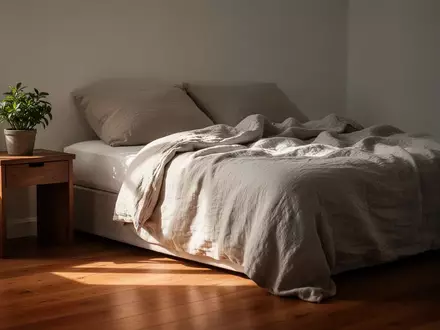 Ein minimalistisch eingerichtetes Schlafzimmer bei Morgenlicht mit einem ungemachten Bett und einer kleinen Zimmerpflanze. - Foto: über boerse-global.de