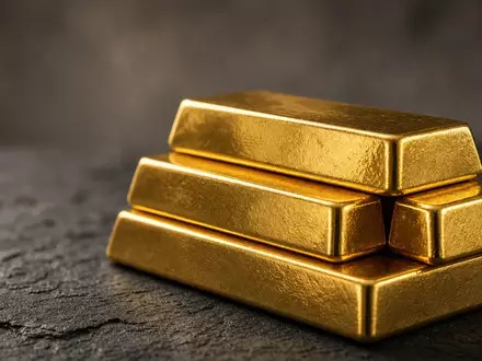 Gestapelte Goldbarren auf einer dunklen, texturierten Oberfläche in weichem, cineastischem Licht. - Foto: über boerse-global.de