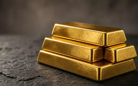 Gestapelte Goldbarren auf einer dunklen, texturierten Oberfläche in weichem, cineastischem Licht. - Foto: über boerse-global.de