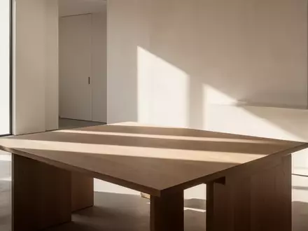 Ein sonnendurchfluteter, minimalistischer Raum mit klaren architektonischen Linien und weichem Tageslicht auf einem Holztisch. - Foto: über boerse-global.de