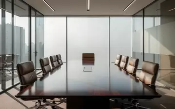 Ein moderner, leerer Konferenzraum mit einem polierten Holztisch und natürlichem Lichteinfall. - Foto: über boerse-global.de