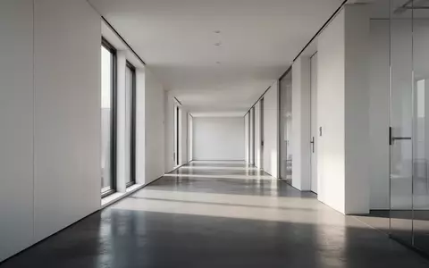 Ein minimalistischer, leerer Büroflur in einem modernen Gebäude mit natürlichem Lichteinfall. - Foto: über boerse-global.de