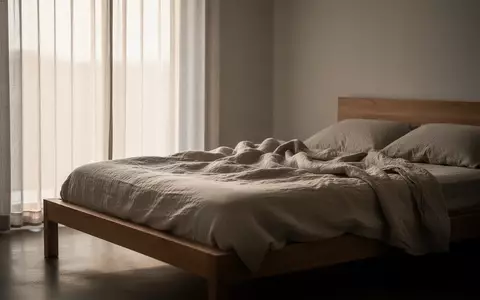 Ein minimalistisch eingerichtetes Schlafzimmer in hellem Tageslicht mit einem ungemachten Bett. - Foto: über boerse-global.de