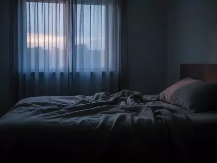 Ein ungemachtes Bett in einem schlafzimmerähnlichen Raum bei morgendlichem Dämmerlicht, das eine ruhige und nachdenkliche Atmosphäre ausstrahlt. - Foto: über boerse-global.de