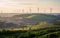 Eine weitläufige, renaturierte Industrielandschaft mit Windkraftanlagen bei Sonnenuntergang im Rheinischen Revier. - Foto: über boerse-global.de