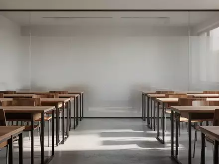 Ein minimalistischer Schulungsraum mit leeren Schreibtischen und großen Glaswänden in hellem Tageslicht. - Foto: über boerse-global.de