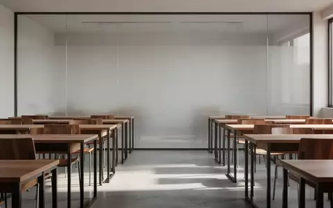 Ein minimalistischer Schulungsraum mit leeren Schreibtischen und großen Glaswänden in hellem Tageslicht. - Foto: über boerse-global.de