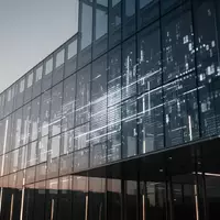 Moderne Glas- und Stahlarchitektur bei Dämmerung als Symbol für technologische Finanzinfrastruktur. - Foto: über boerse-global.de