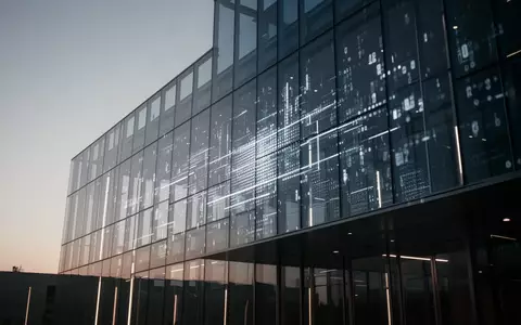 Moderne Glas- und Stahlarchitektur bei Dämmerung als Symbol für technologische Finanzinfrastruktur. - Foto: über boerse-global.de