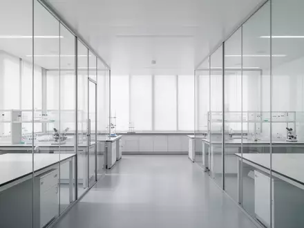 Ein minimalistisches, helles Labor mit Glaswänden und neutralem Interieur, das Ordnung und Struktur symbolisiert. - Foto: über boerse-global.de