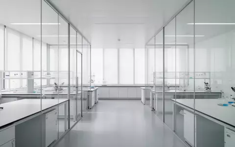 Ein minimalistisches, helles Labor mit Glaswänden und neutralem Interieur, das Ordnung und Struktur symbolisiert. - Foto: über boerse-global.de