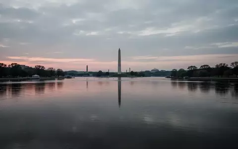 Ein ruhiger Flussabschnitt bei Dämmerung mit dem Washington Monument in der fernen Silhouette unter einem bewölkten Himmel. - Foto: über boerse-global.de