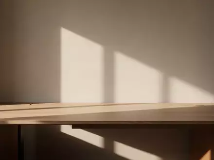 Ein minimalistischer, heller Arbeitsbereich mit einem leeren Holztisch und sanftem Lichteinfall. - Foto: über boerse-global.de