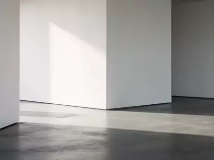 Ein minimalistischer, moderner Innenraum mit klaren Linien, poliertem Betonboden und weichem Tageslicht, das lange Schatten wirft. - Foto: ĂĽber boerse-global.de