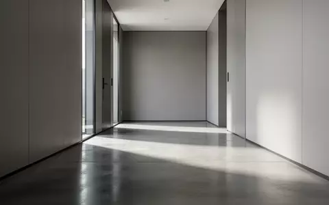 Ein leerer, modern gestalteter Büroflur mit Betonboden und neutralen Wänden in einer sachlichen, ruhigen Atmosphäre. - Foto: über boerse-global.de