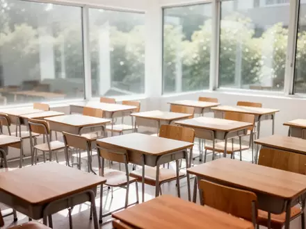 Ein heller, leerer Klassenraum mit Holztischen und Stühlen in einer modernen Schule bei Tageslicht. - Foto: über boerse-global.de