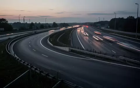 Eine leere Autobahnauffahrt in der Dämmerung mit Leitplanken und asphaltierter Fahrbahn. - Foto: über boerse-global.de