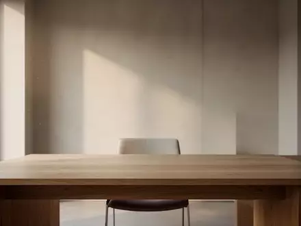 Ein minimalistischer, moderner Arbeitsplatz mit einem leeren Holztisch in einem hellen Raum bei natürlichem Tageslicht. - Foto: über boerse-global.de