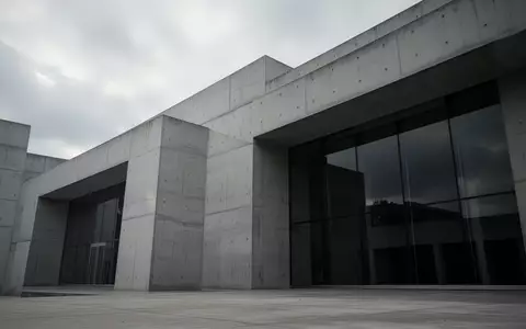 Ein minimalistisches, modernes Regierungsgebäude aus Beton unter einem bewölkten Himmel ohne sichtbare Schriftzüge. - Foto: über boerse-global.de