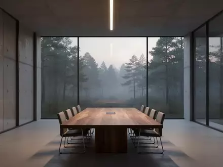 Ein minimalistischer, leerer Konferenzraum mit bodentiefen Fenstern und Blick auf einen nebligen Wald, der Professionalität und strategische Planung symbolisiert. - Foto: über boerse-global.de