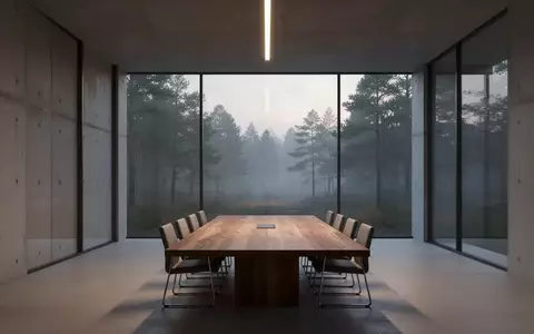 Ein minimalistischer, leerer Konferenzraum mit bodentiefen Fenstern und Blick auf einen nebligen Wald, der Professionalität und strategische Planung symbolisiert. - Foto: über boerse-global.de