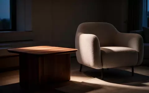 Ein minimalistisch eingerichtetes Wohnzimmer bei Dämmerung mit einem leeren Beistelltisch neben einem Sessel. - Foto: über boerse-global.de