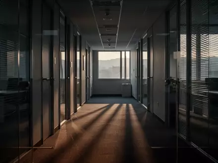 Ein leerer, in Dämmerlicht getauchter Büroflur mit langen Schatten, der die Atmosphäre zum Ende der Arbeitswoche einfängt. - Foto: über boerse-global.de