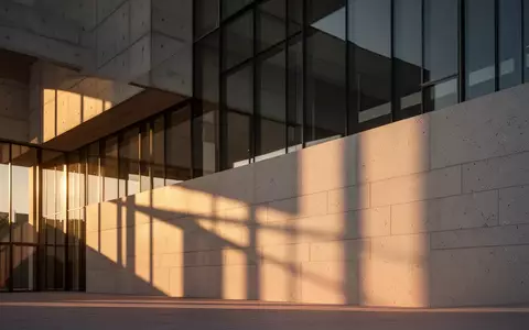Architektonisches Detail eines modernen Gebäudes mit geometrischen Schattenwürfen auf einer Betonfassade. - Foto: über boerse-global.de