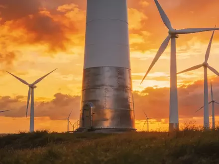 Moderne Windkraftanlagen in einem Windpark bei Sonnenaufgang. - Foto: über boerse-global.de