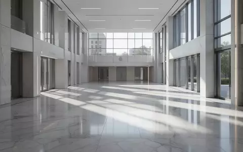 Ein minimalistisches, helles Innenraumfoto eines öffentlichen Gebäudes mit poliertem Boden und geometrischen Schatten. - Foto: über boerse-global.de