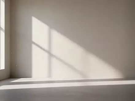 Ein minimalistischer, heller Raum mit klaren geometrischen Schatten an einer leeren Wand. - Foto: über boerse-global.de