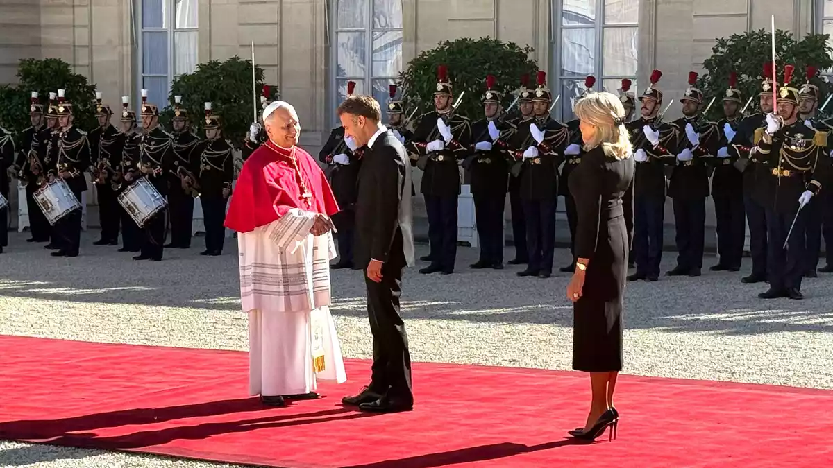 Frankreichs Präsident Emmanuel Macron und seine Ehefrau Brigitte schütteln Hände mit dem Papst im Hof des Élysée-Palastes. - Bild: Christoph Sator/dpa