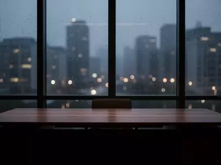 Ein dunkles, leeres Büro mit Blick auf eine verschwommene nächtliche Stadtlandschaft bei Regen. - Foto: über boerse-global.de