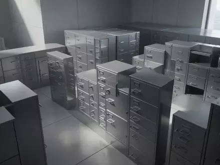 Ein minimalistischer, moderner Archivraum in einem Finanzgebäude mit schlichten, leeren Aktenschränken in natürlichem Licht. - Foto: über boerse-global.de
