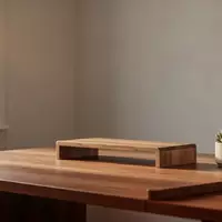 Ein aufgeräumter, minimalistischer Schreibtisch in einem Homeoffice mit natürlichem Licht, Monitorständer und einer Pflanze. - Foto: über boerse-global.de